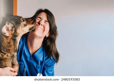 Veterinarian, Happy stray dog licking vet woman doctor face inside private hospital - Powered by Shutterstock