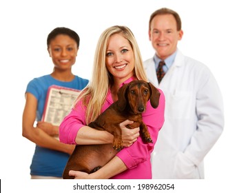 Veterinarian: Pet Owner Holds Dachshund With Vet And Assistant Behind