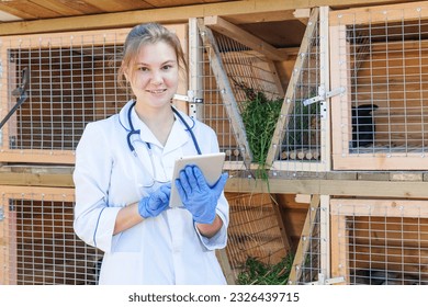 Veterinarian woman with tablet computer checking animal health status on barn ranch background. Vet doctor check up rabbit in natural eco farm. Animal care and ecological livestock farming concept - Powered by Shutterstock