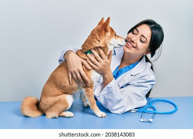 Veterinarian Woman Wearing Uniform At The Clinic, Hugging Dog With Love