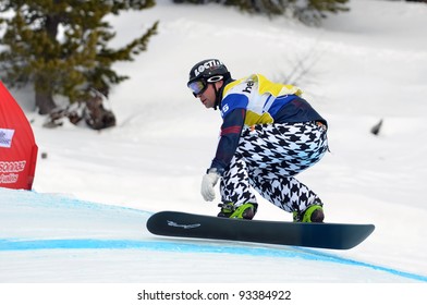 VEYSONNAZ, SWITZERLAND - JANUARY 22: finalist Nick Baumgartner (USA) on a jump in the FIS World Championship Snowboard Cross finals : January 22, 2012 in Veysonnaz Switzerland