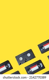 VHS Video Cassette, Old Black Videotape Pattern On A Yellow Background, Outdated Technology Background. 