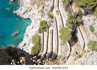Via Krupp, Capri island, Italy, the famous hairpin turn road on a steep rocky cliff over blue Mediterranean sea in the Bay of Naples