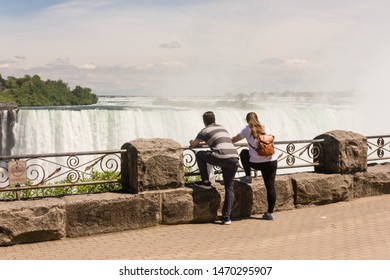 Viagra Falls, Ontario / Canada - June 18, 2019: Two Millennial Travelers Enjoying The View Of Niagra Falls. 