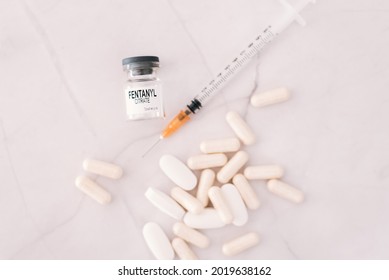 Vial And Pills Of Fentanyl, An Opioid Responsible For The Drug Addiction And Abuse Death Crisis In The United States, Defocused Background.