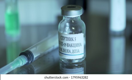 Vial Of Russian Vaccine Or Sputnik V On A Table With A Syringe