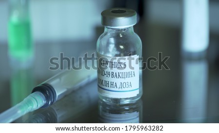 vial of russian vaccine or sputnik v on a table with a syringe