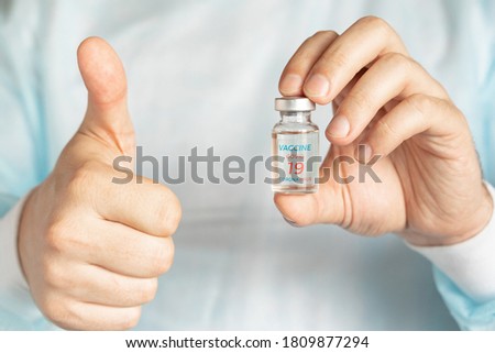 Vial with usa, american vaccine for covid-19 coronavirus,flu, infectious diseases.Vaccination support,approval.Hand of doctor.Thumb up.Clinical trials of injection for administration for human,people.