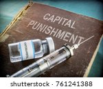  Vial And Vintage Syringe With Medicine On An Old Book Of Capital Punishment, Conceptual 