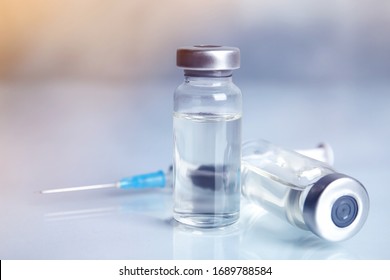 Vials and syringe on light table. Vaccination and immunization