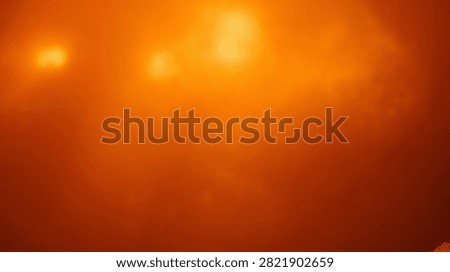 A vibrant abstract background featuring a warm gradient of orange and yellow hues, with subtle soft light effects creating a glowing atmosphere.
