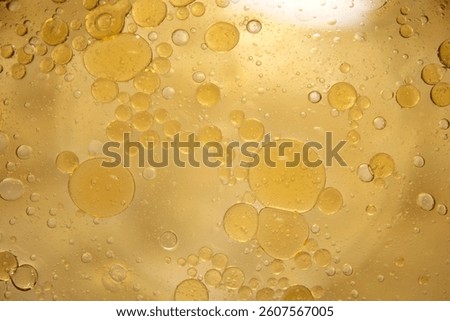 Vibrant abstract image featuring bubbles and droplets in a viscous yellow liquid. This stunning close-up showcases texture and fluid movement, ideal for enhancing visual projects.