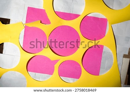 A vibrant abstract layout featuring layered yellow, pink, and white paper scraps from an art project. The composition showcases a complex arrangement of circles and rectangles with visible tactile textures and 