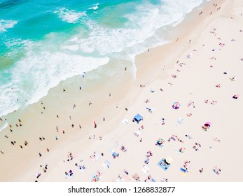 A vibrant aerial view of people at the beach on a busy summer day in Surfers Paradise on the Gold Coast in Queensland, Australia with turquoise water