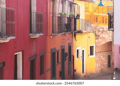 Vibrant alley in Guanajuato's old town with colorful Spanish colonial buildings and balconies filled with potted plants. - Powered by Shutterstock