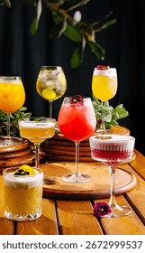 A vibrant array of cocktails is presented on round wooden coasters. Each drink is garnished with fresh fruits and flowers, showcasing a lively bar atmosphere perfect for social gatherings.