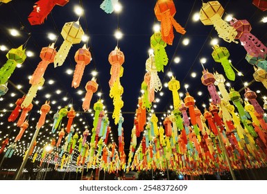  a vibrant array of colorful paper lanterns hanging from above, illuminated against a night sky. The lanterns are in various shapes and colors, creating a festive and lively atmosphere.  - Powered by Shutterstock