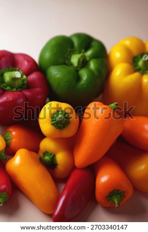 vibrant array of fresh red, yellow, orange, and green bell peppers in natural light on soft neutral background highlighting their glossy textures and organic bounty, neutral, unprocessed, array