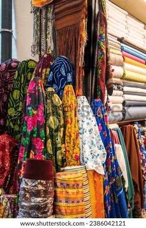 A vibrant assortment of colourful scarves and miscellaneous items, a testament to the rich tapestry of Turkish culture and craftsmanship, on display in the bustling Grand Bazaar of Istanbul