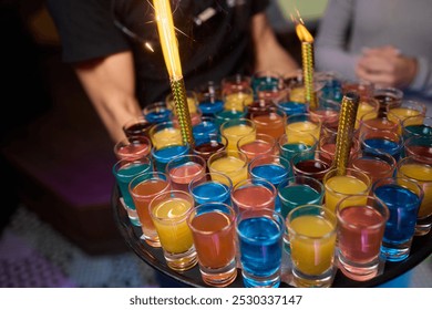 A vibrant assortment of shot glasses arranged for a cheerful gathering, perfect for celebrations and toasts - Powered by Shutterstock