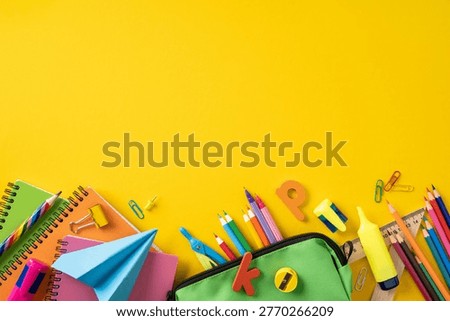Vibrant back to school flat lay featuring colored pencils, notebooks, paper plane, highlighter and stationery essentials arranged on a bright yellow background for education and study projects