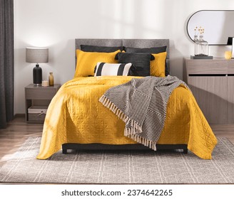 Vibrant Bedroom Atmosphere, Quilted Yellow Comforter Contrasting with Monochrome Throw Blanket on Cozy bed, Accented by Sleek Gray Nightstand, Minimalist Wooden Dresser, Over a Complementary Area Rug.