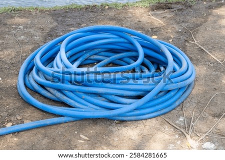 Similar – Image, Stock Photo Garden hose lies on a square terrace of stone tiles in a well-kept garden with lawn and a planting strip