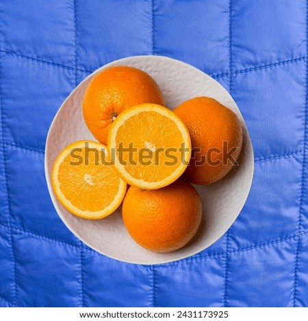Vibrant bowl of oranges arranged on a serene blue blanket, offering a refreshing and colorful composition. Perfect for concepts of freshness, wellness, and relaxation. #orangefruit 🍊