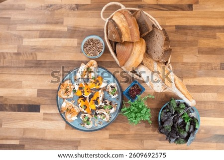 A vibrant brunch spread featuring artisanal breads, fresh greens, and colorful crostini topped with creamy cheeses, smoked salmon, peppers, and edible flowers — a rustic celebration of flavor.