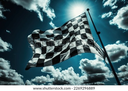 A vibrant checkered flag waving in the sky, viewed from a low angle as clouds pass by. 