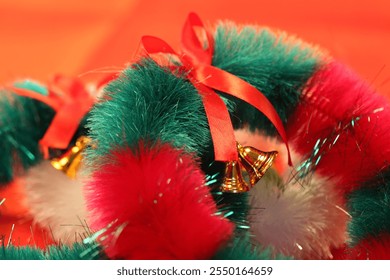 A vibrant close-up of Christmas decorations hanging from a green tinsel garland. A reflective blue disco ball ornament, a soft pink snowflake, and blurred ornaments in the background. - Powered by Shutterstock