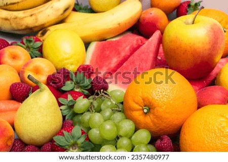 A vibrant close-up of fresh, colorful fruits, including oranges, strawberries, plums, blackberries, apples, bananas, pears, grapes, watermelon and lemons. Ideal for healthy living concepts