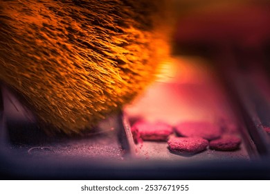 A vibrant close-up of a makeup brush with fine bristles coated in powder, highlighting a burst of color and texture. - Powered by Shutterstock