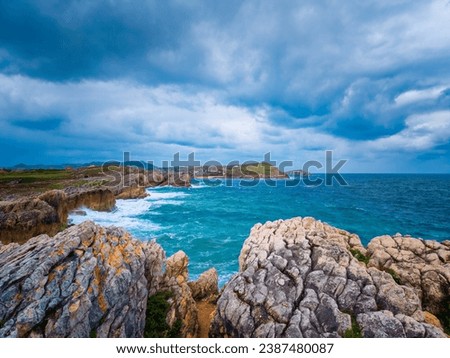 Vibrant cloudy skies over the rugged beauty of Costa Quebrada, Isle of Virgen del Mar, capturing dramatic coastal allure in a picturesque play of nature's contrasts.
