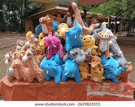 A vibrant collection of animal plush toys, including elephants, giraffes, and other characters, neatly arranged on a street stall. Ideal for themes of childhood, toys, and outdoor markets