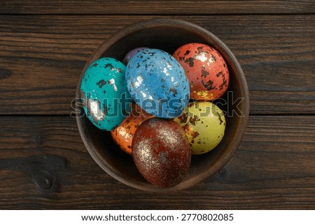 Vibrant Colored Easter Eggs in a Rustic Wooden Bowl on Dark Wooden Background