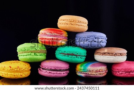 Vibrant and colorful assortment of macarons artfully arranged on a pristine black surface, creating an enticing display of reflections.