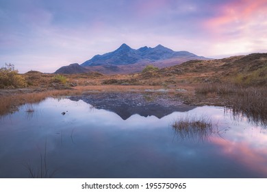 Vibrant, colourful pastel  sunset or sunrise over calm, serene, landscape reflection of the Black Cuillin Mountains at Sligachan on the Isle of Skye, Scotland.