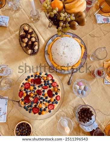 A vibrant dessert table set up with an array of delicious items including cakes, fresh fruits, chocolate candies, and decorative arrangements, ready for a festive celebration.