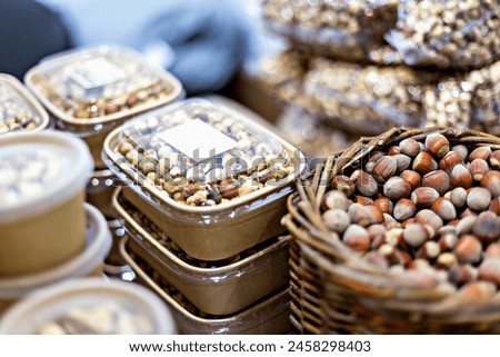 Vibrant display of assorted nuts in containers and baskets, showcasing variety of textures and colors, perfect for culinary and healthy lifestyle themes. Selective focus, defocus