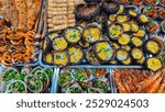 Vibrant and diverse street food stall overflowing with variety of grilled and cooked dishes on Cho Dem nightmarket in Duong Dong, Phu Quoc island, Vietnam, South East Asia. Grilled Skewers and seafood