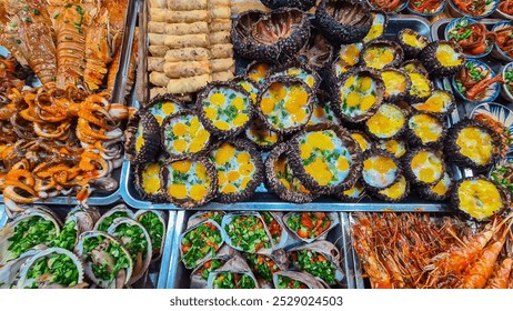 Vibrant and diverse street food stall overflowing with variety of grilled and cooked dishes on Cho Dem nightmarket in Duong Dong, Phu Quoc island, Vietnam, South East Asia. Grilled Skewers and seafood - Powered by Shutterstock