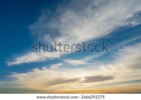 A vibrant and dramatic sky with wispy clouds, showcasing the transition from bright blue to a warm, golden hue as the sun sets. The photo was taken during a Nile cruise near Luxor and Esna.