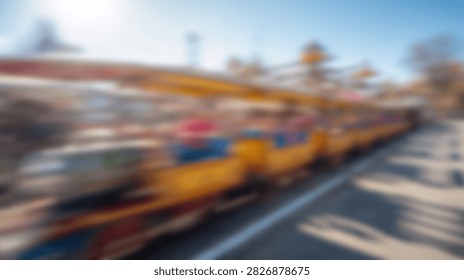 A vibrant and dynamic image capturing the blurred motion of a thrilling amusement park ride under a clear blue sky.
