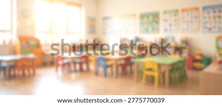 A vibrant and empty kindergarten classroom, featuring small, colorful tables and chairs, bathed in bright natural light. The room is ready for children to learn and play.