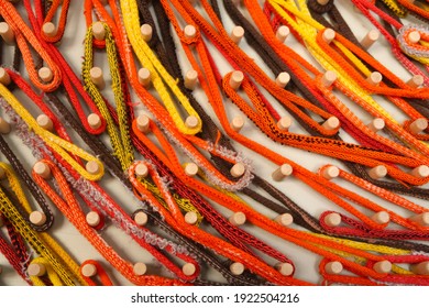 Vibrant Fabric Loops Decorate A Wooden Peg Board                              