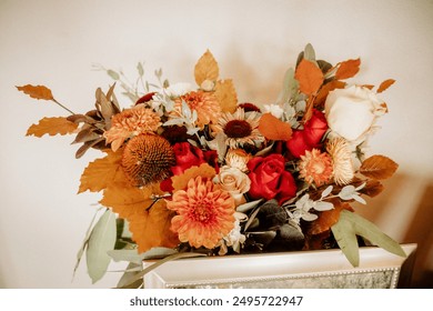 A vibrant floral arrangement featuring autumn colors with roses and chrysanthemums, set in an elegant vase. The beautiful bouquet adds a touch of seasonal charm and warmth to any space - Powered by Shutterstock