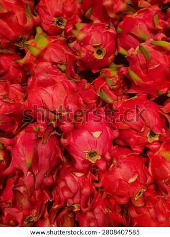 Vibrant full-frame texture of fresh red dragon fruit pitaya stacked tightly together. Colorful, high-quality agricultural produce background for healthy food and diet concepts.
