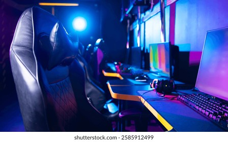 Vibrant gaming setup with high-tech computers and ergonomic chairs in neon lighting.