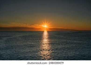 A vibrant golden sunrise over the Skagerrak North Sea, with the sun rays reflecting off the water, near the Norwegian and Swedish coast
 - Powered by Shutterstock